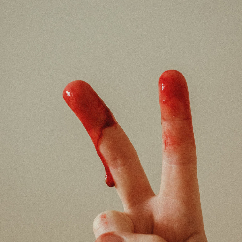 Peace Zeichen mit Zeigefinger und Mittelfinger mit Blut bedeckt